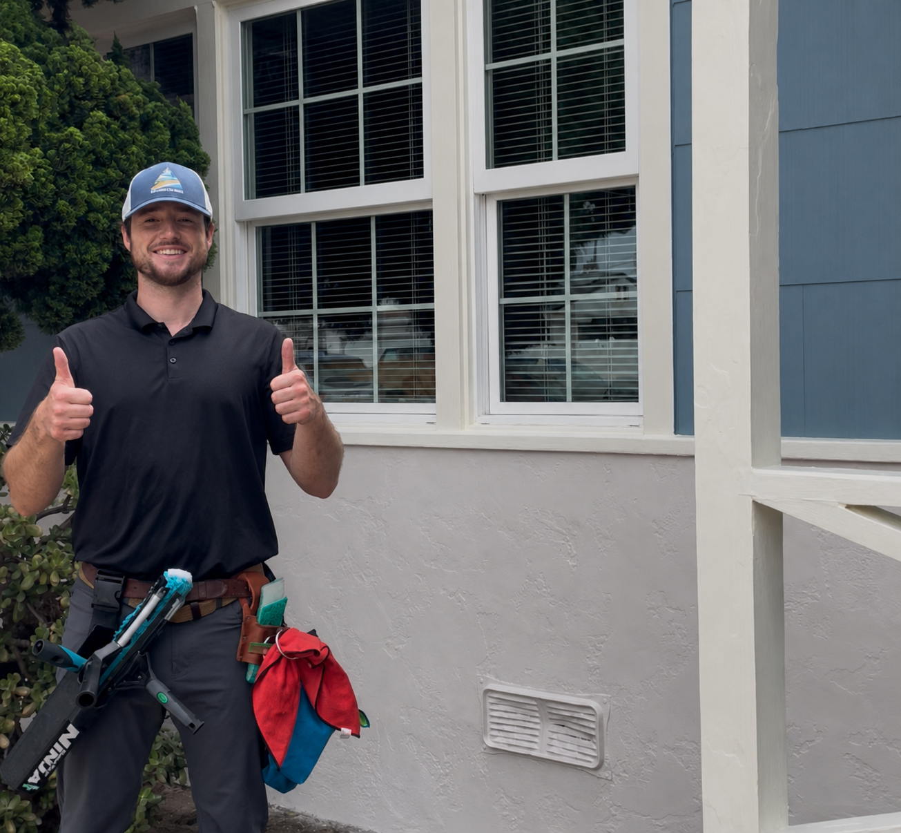 Evan from Blue Oak Window Cleaning smiling outside a home